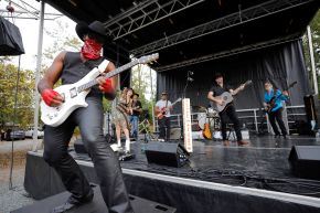 guitarist with cowboy hat and bandana on stage with his band at Carrboro Music Festival